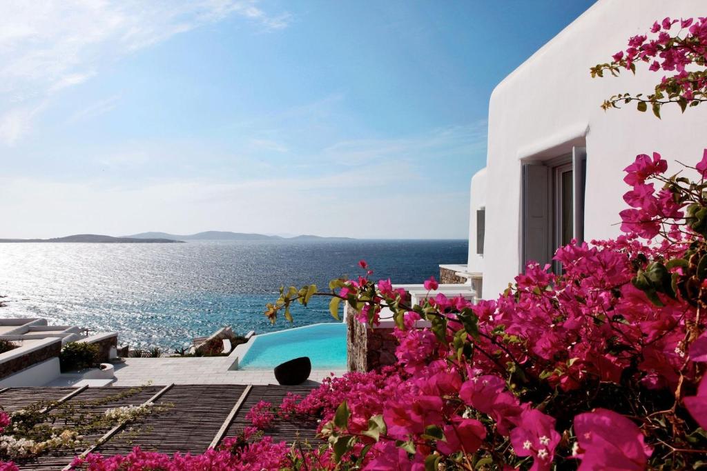 a house with a view of the water and flowers at Astounding Mykonos Villa 6 Bedrooms Villa El Greco Panoramic Sea Views Facing the Ancient Island of Delos Aleomandra in Dexamenes