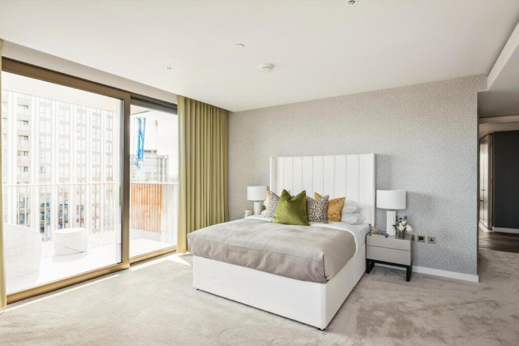 een slaapkamer met een bed en een groot raam bij Hestia Residences in Londen