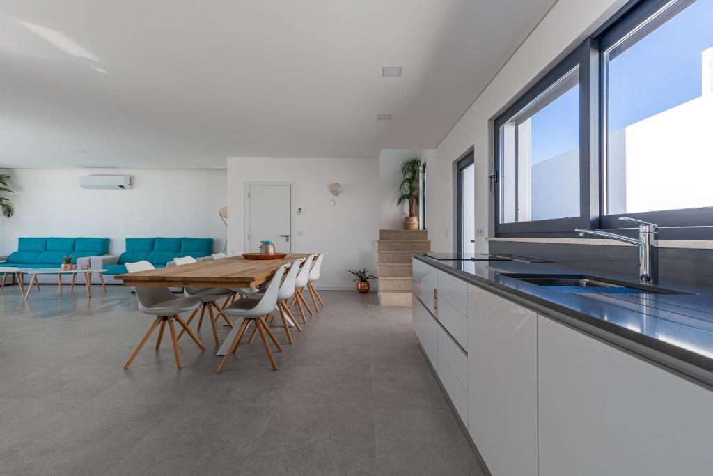 a kitchen and dining room with a table and chairs at Villa Locki in Lourinhã