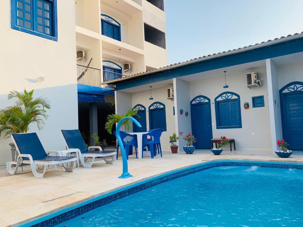a villa with a swimming pool and blue doors at Pousada Vila de Charme in Barreirinhas