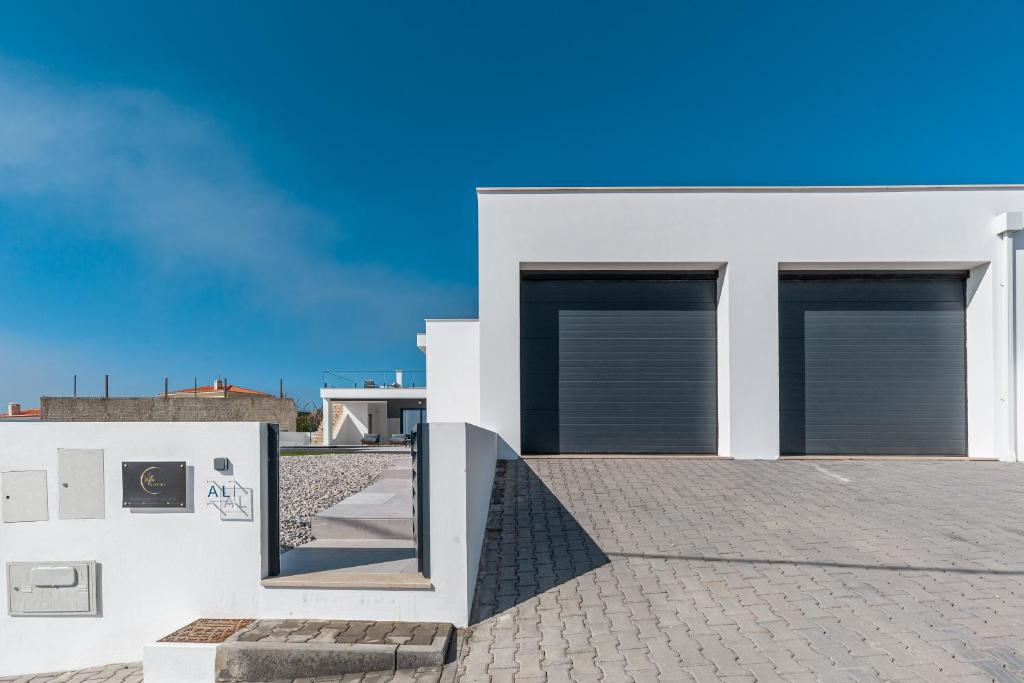 a white house with two windows and a blue sky at Villa Locki in Lourinhã