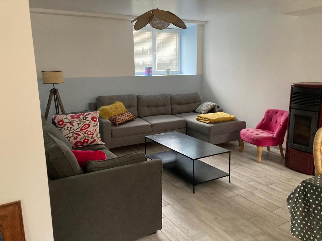 a living room with a couch and a table at Le gîte de la rue in Gréville-Hague