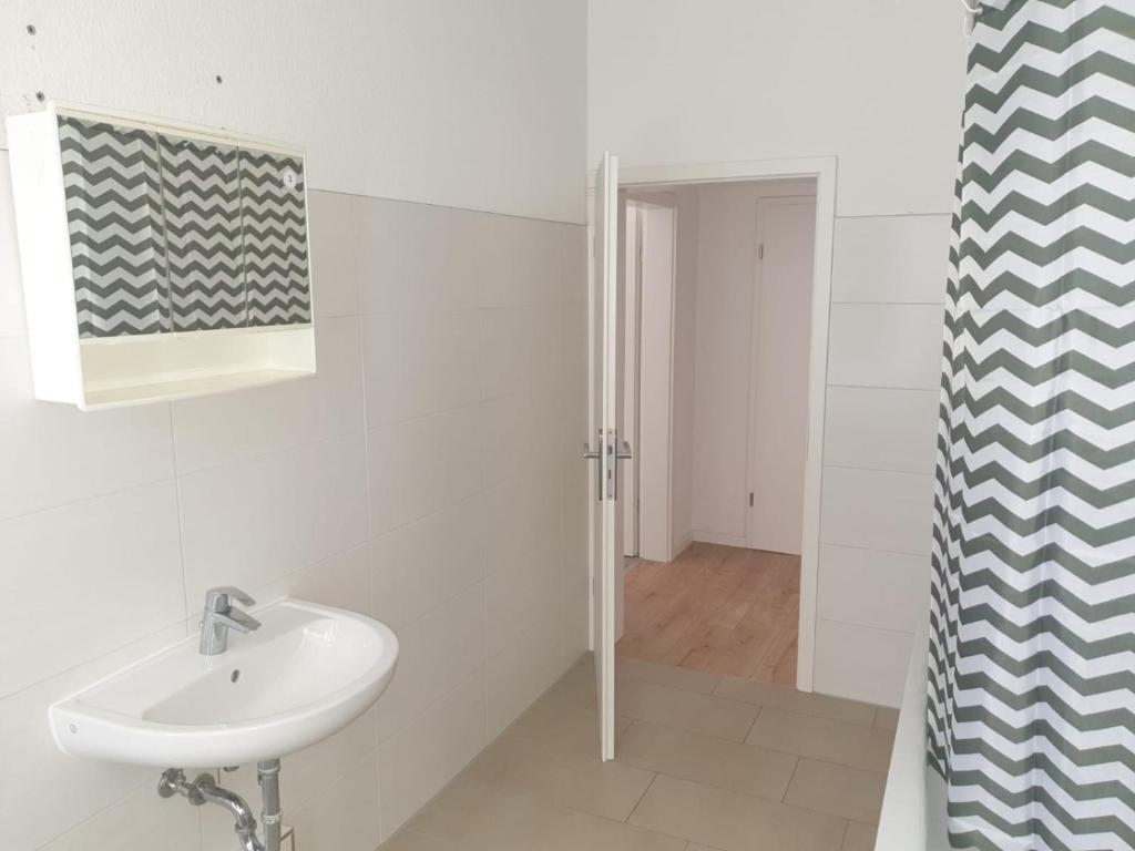 a white bathroom with a sink and a shower at Ferien Wohnungen in Wurzen