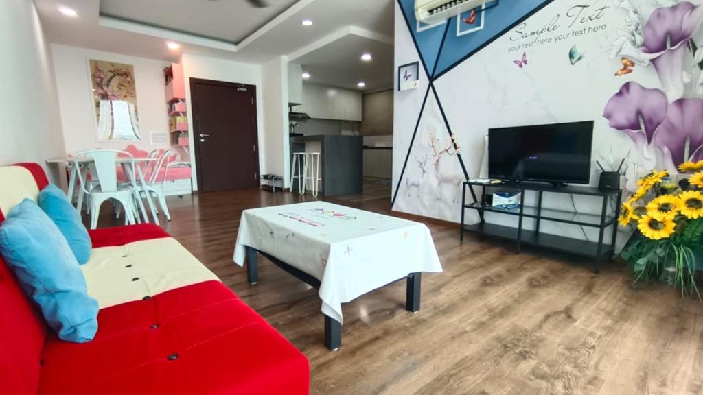 een woonkamer met een rode bank en een tv bij Mupify Homestay Jazz Suites 4 in Kuching