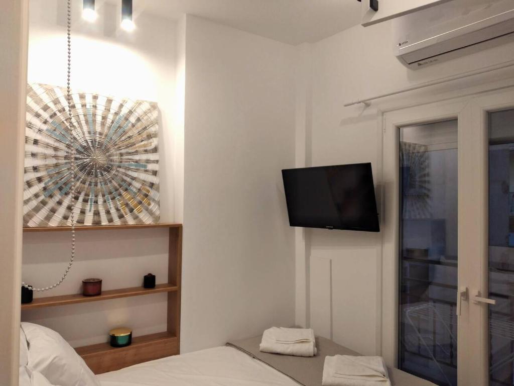 Zimmer mit einem Bett und einem TV an der Wand in der Unterkunft Modi Stay in Thessaloniki
