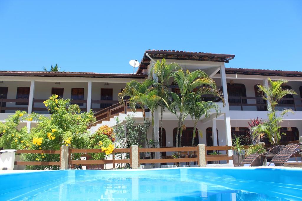 un complejo con piscina frente a un edificio en Pousada Encantos de Arraial, en Arraial d'Ajuda