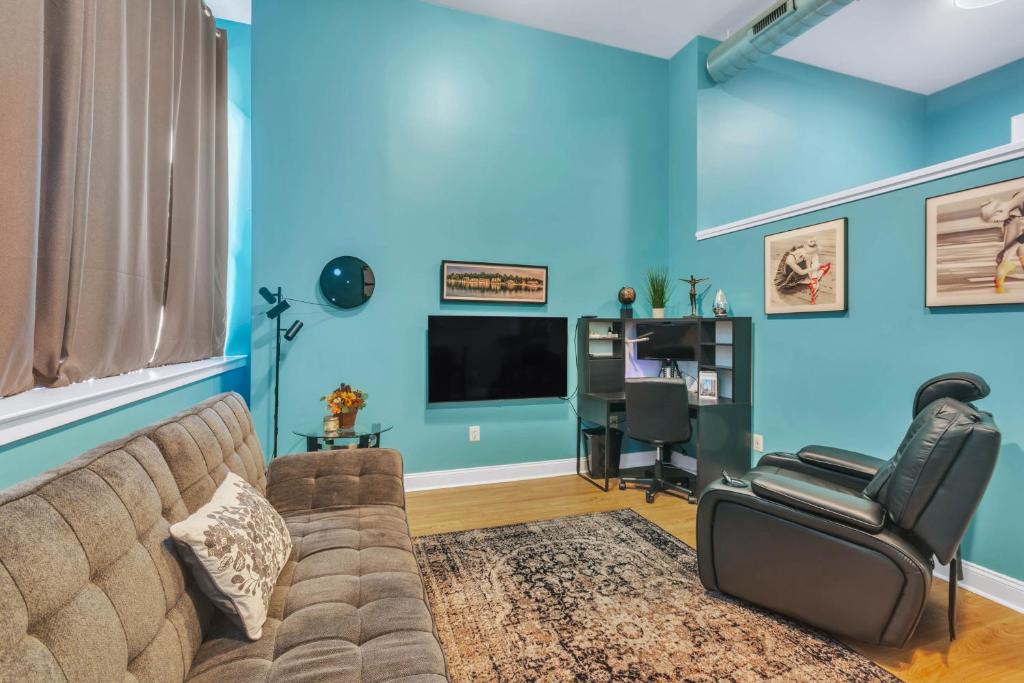 Broad Street Apartment في فيلادلفيا: غرفة معيشة مع أريكة وكرسي