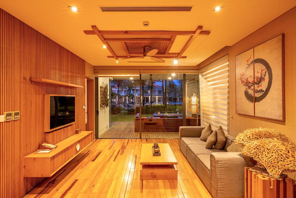 a living room with a couch and a table at Maha Mangala Zen Garden & Residence in Danang
