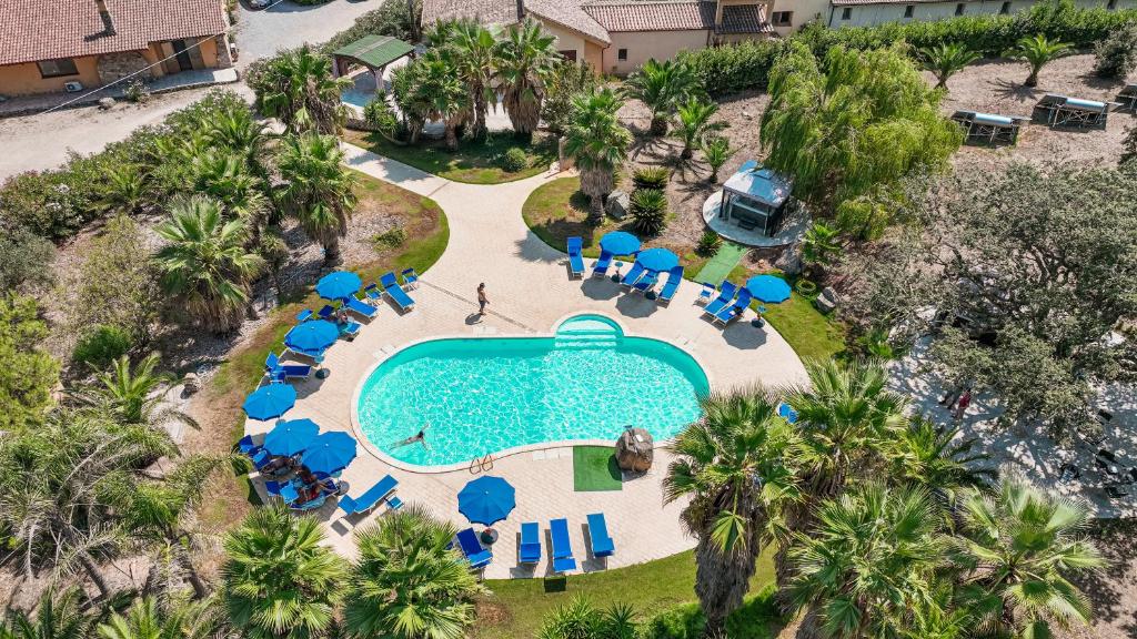 an overhead view of a swimming pool with blue chairs and palm trees at Agriturismo Rocce Bianche - Porticato in Arbus