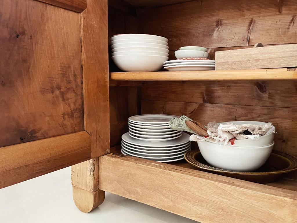 a wooden cabinet with plates and bowls in it at Casa Petita, Villajoyosa in Villajoyosa