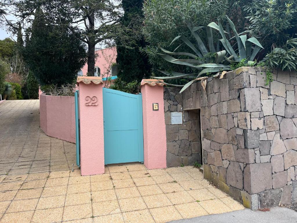 une porte bleue et rose avec un mur en pierre dans l'établissement Villa du Cap de 5 chambres et sa grande piscine, au Cap d'Agde
