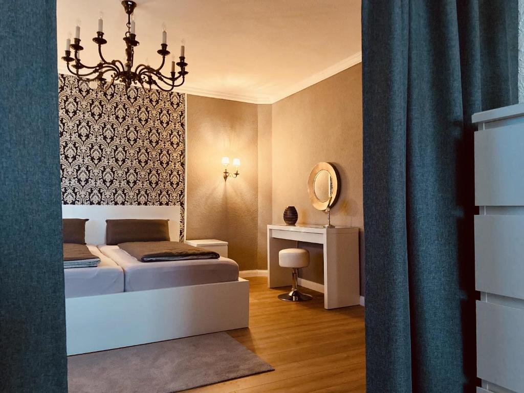 a bedroom with a bed and a chandelier at CASA REHSE I Stilvolles Apartment I 24h-Self-Check-in I kostenlos Parken & WLAN I 55-Zoll-Smart&Kabel-TV I ÖPNV in Erfurt