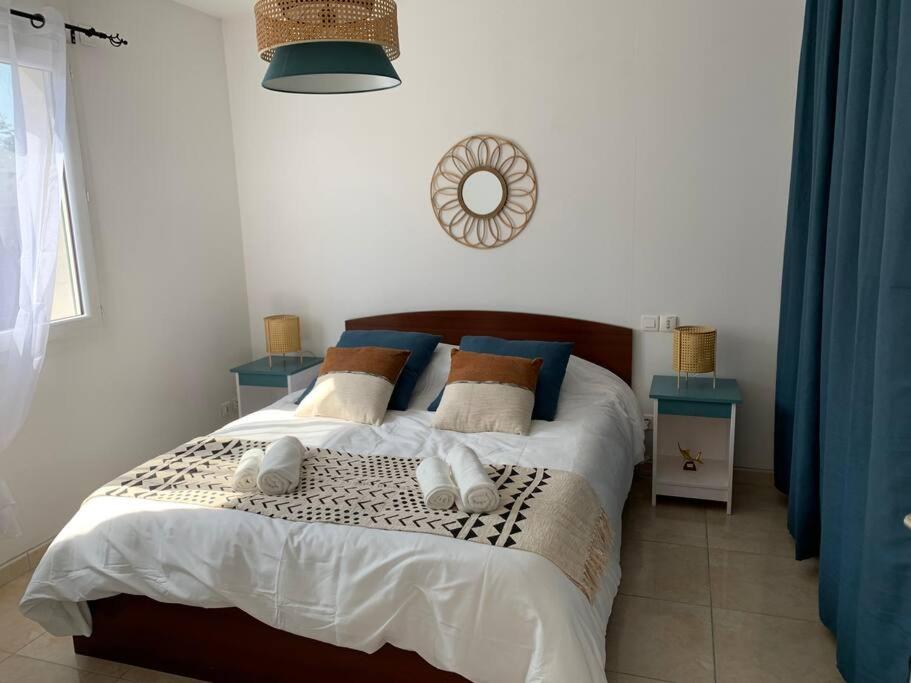 sypialnia z łóżkiem z poduszkami i zegarem na ścianie w obiekcie Maison au cœur du Pic Saint Loup w mieście Sainte-Croix-de-Quintillargues