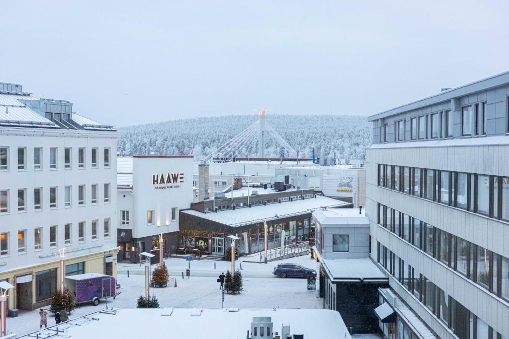 eine Stadtstraße mit schneebedeckten Gebäuden und einer Brücke in der Unterkunft Lapinmaa Apartments in Rovaniemi