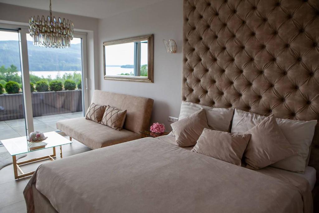 a bedroom with a large bed with a large padded headboard at Jollien apartmán Gold in Námestovo