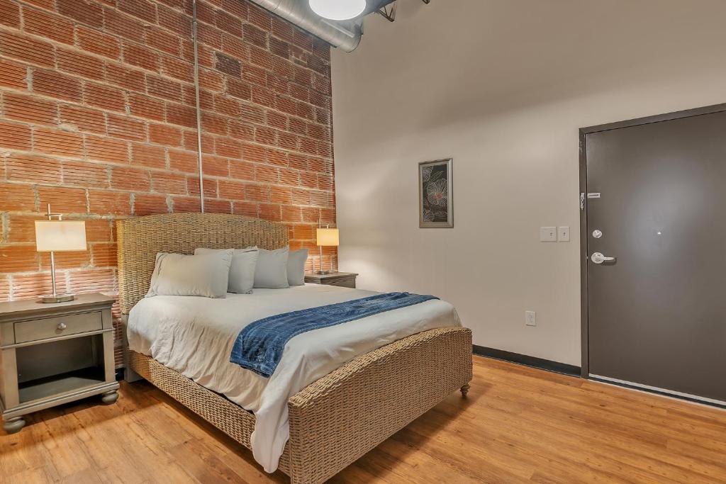 a bedroom with a bed and a brick wall at 2 Bedroom Loft @ Grand Strand Brewery 205 in Myrtle Beach