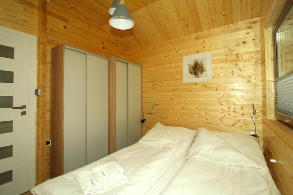 Postel nebo postele na pokoji v ubytování Całoroczny drewniany domek Superior i apartamenty Eko-oaza w Krynica Morska-Piaski