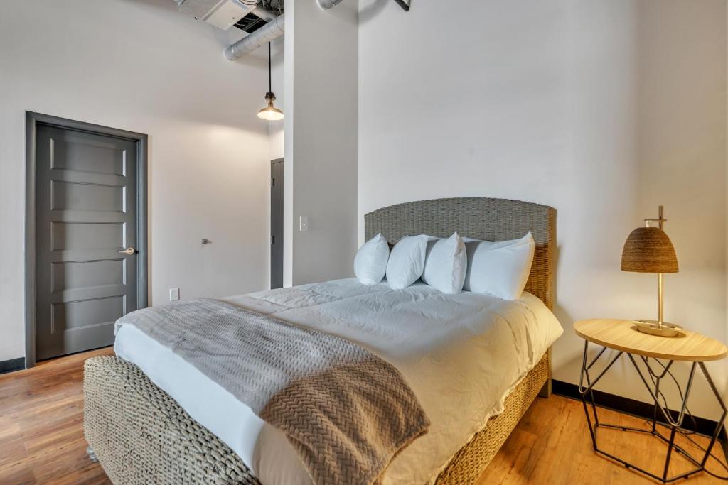 a bedroom with a bed and a table with a lamp at Hoppy Hideaway: Coastal Loft with a Brewery Twist in Myrtle Beach