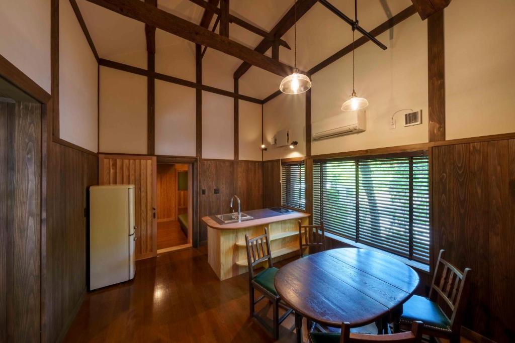 Obuse的住宿－ゲストハウス小布施，厨房配有木桌和冰箱。