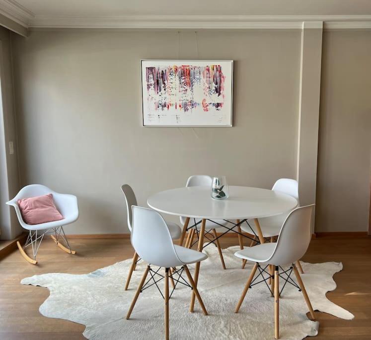 uma sala de jantar com uma mesa branca e cadeiras em Zoute penthouse (near place Albert) em Knokke-Heist