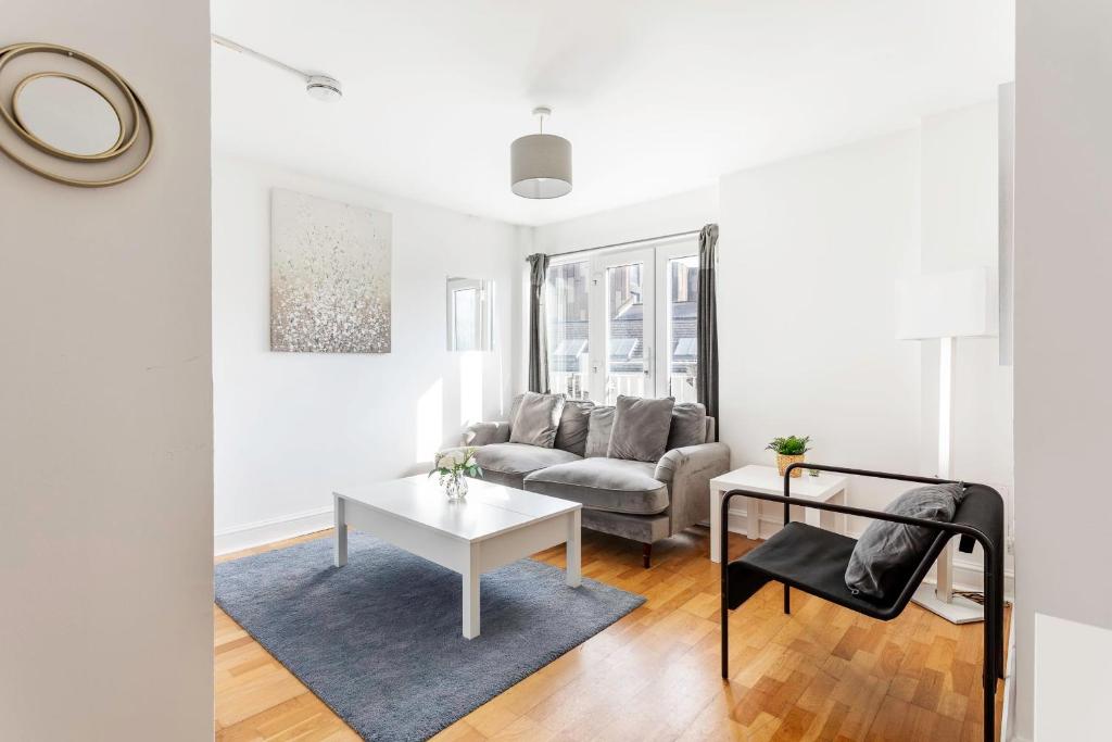 a living room with a couch and a table at Modern Home Near Central London in London