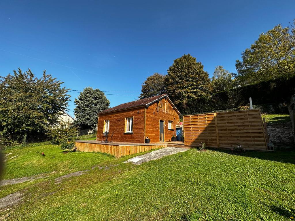 a small wooden house in a grassy field at Le Tipani in Vernon