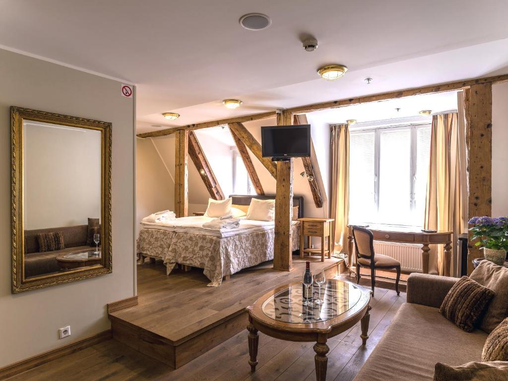 a living room with a bed and a mirror at CRU Hotel in Tallinn