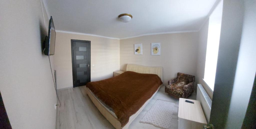 um pequeno quarto com uma cama com um cobertor castanho em вулиця Нагiрна em Kamianets-Podilskyi