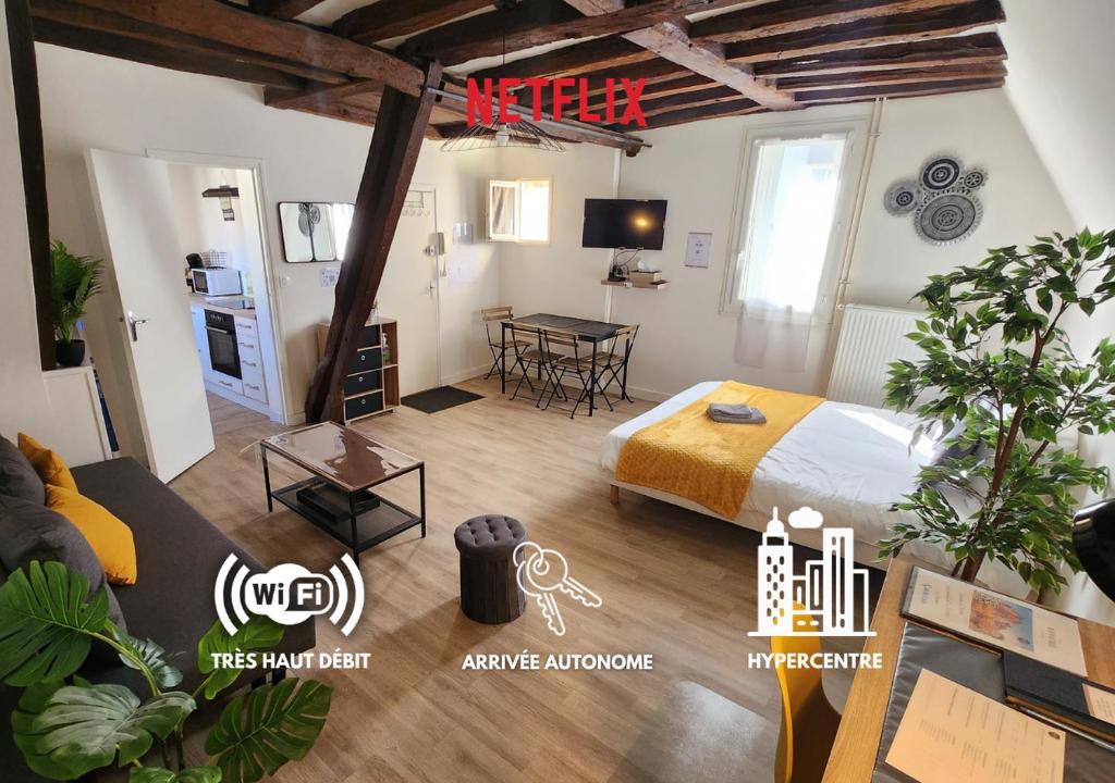 a bedroom with a bed and a table in a room at L'Etape Tourangelle in Tours