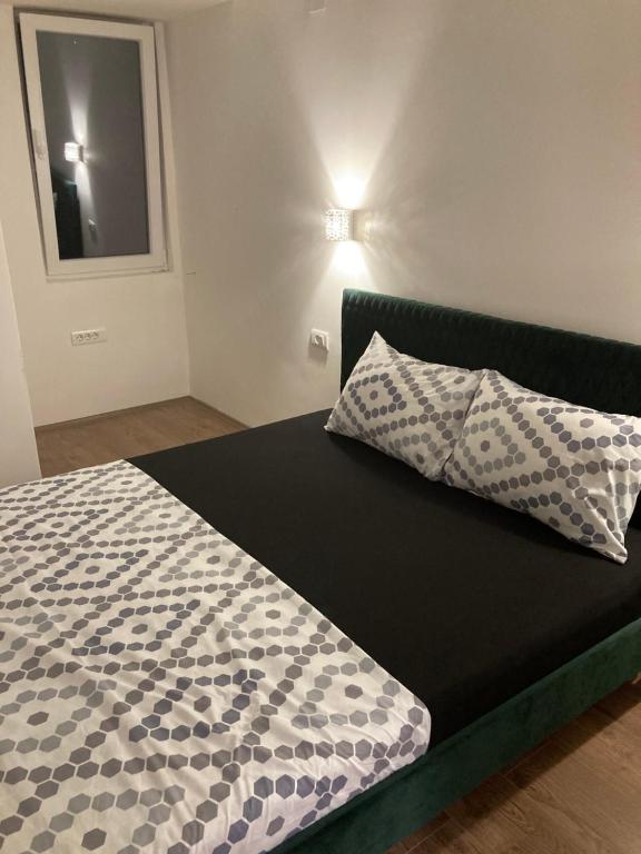 a bed with two pillows on it in a room at Relax in Apartment Stela in Skopje
