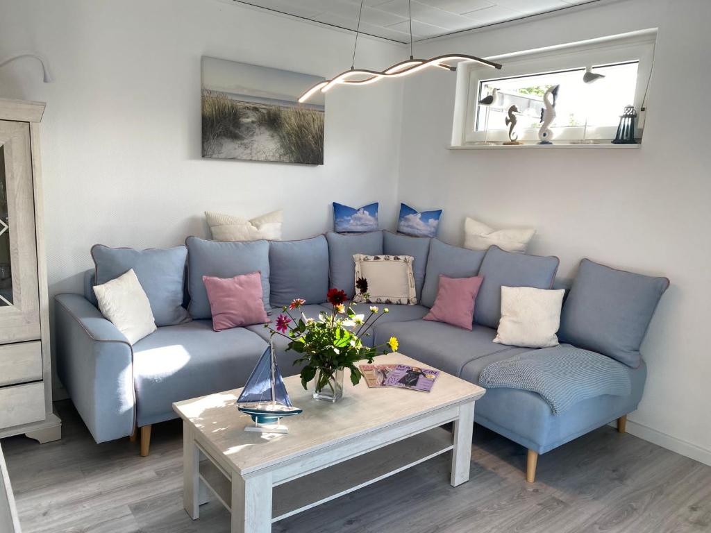 sala de estar con sofá azul y mesa en Haus Sansibar Niendorf, en Timmendorfer Strand