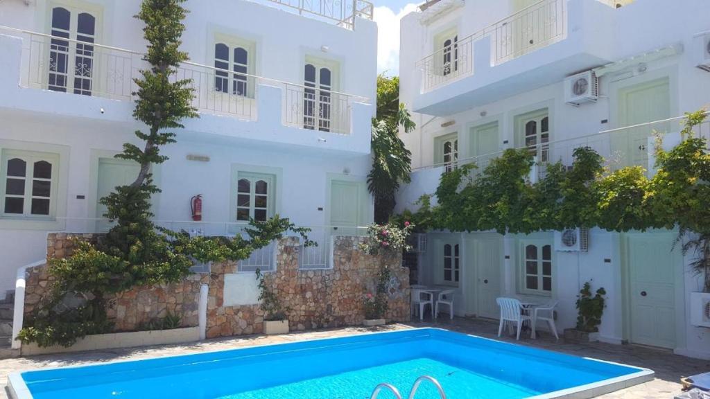a villa with a swimming pool in front of a building at Optasia Apartments in Hersonissos