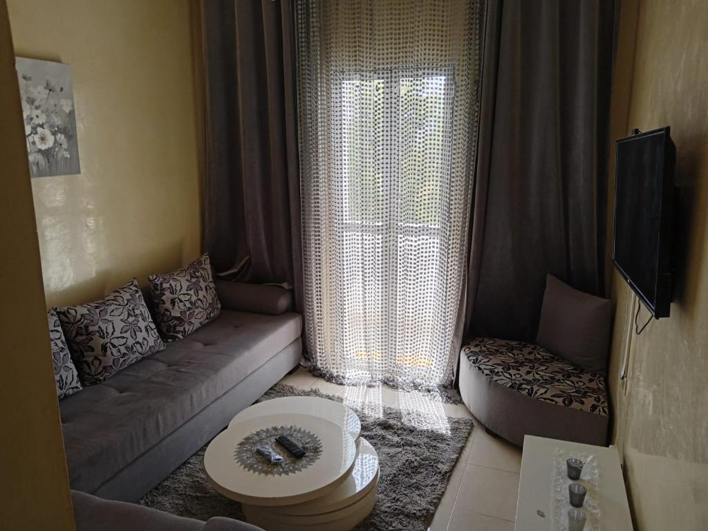 een woonkamer met een bank en een raam bij Appartement la vallée in Safi