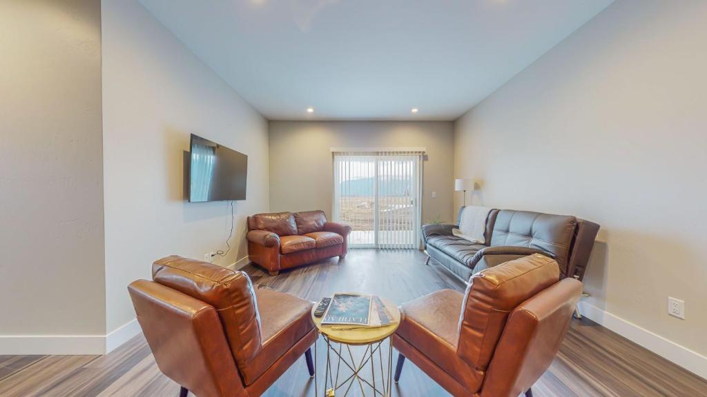 sala de estar con muebles de cuero y TV en Scenic Mountain Views at Olympia Way-Unit A, en Kalispell