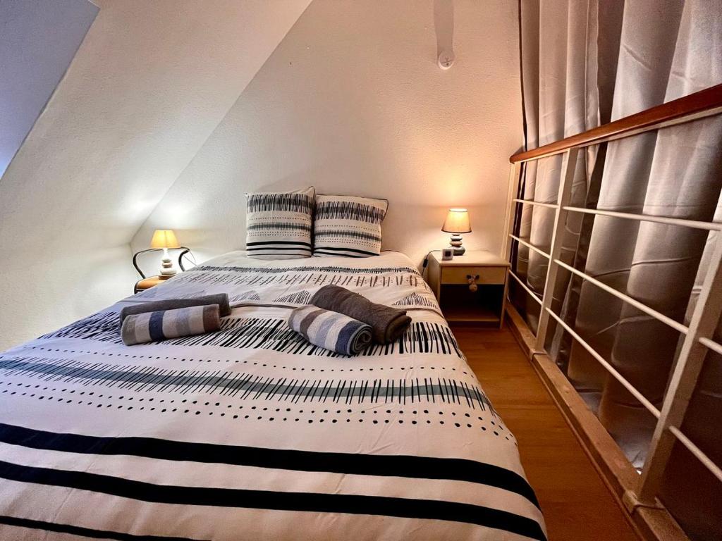 a bedroom with a large bed with pillows on it at Keraven, charmante maisonnette, piscine commune 1-4 personnes in Moëlan-sur-Mer