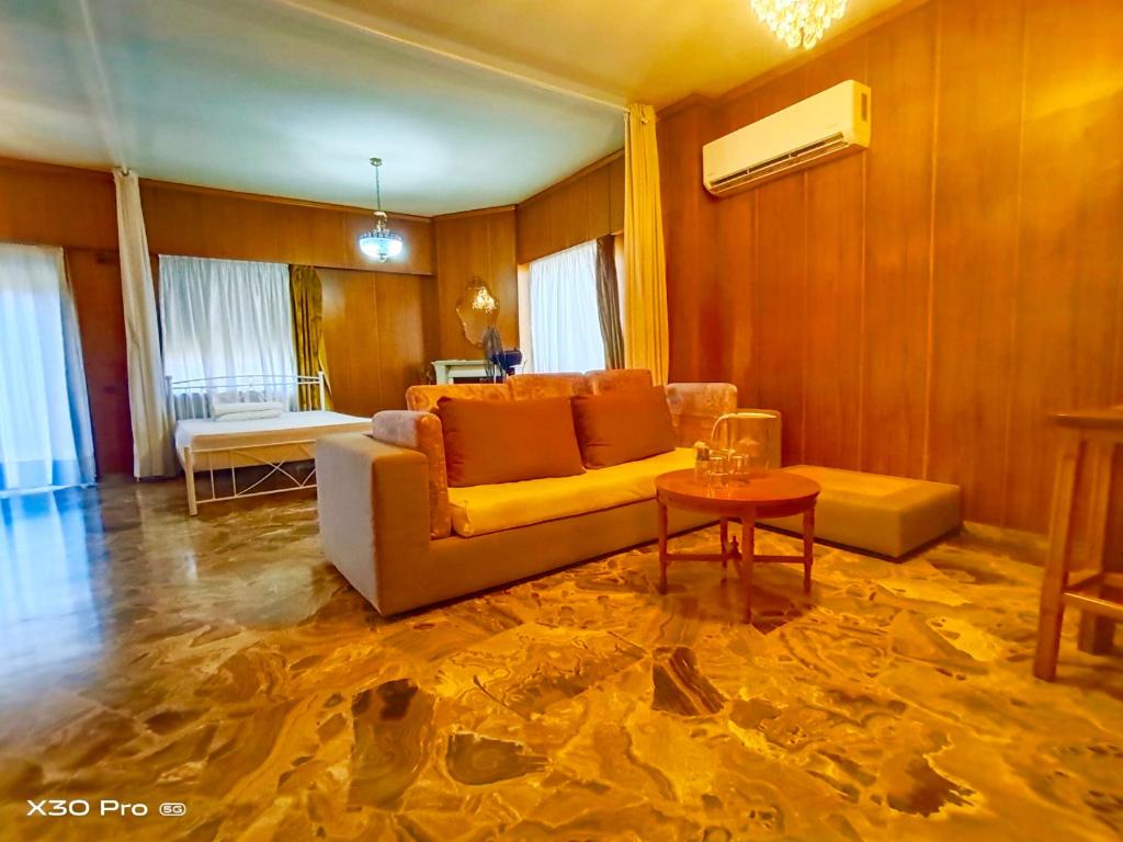 een woonkamer met een bank en een tafel bij 爱心小屋 温馨如家 in Piraeus