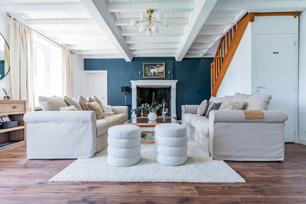 a living room with white furniture and a blue wall at No2 By The Fields in Canchy