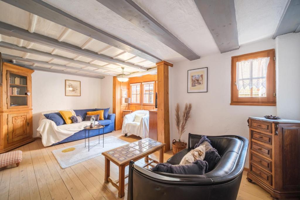 uma sala de estar com um sofá azul e uma mesa em L Oriel du Rempart Nord em Eguisheim
