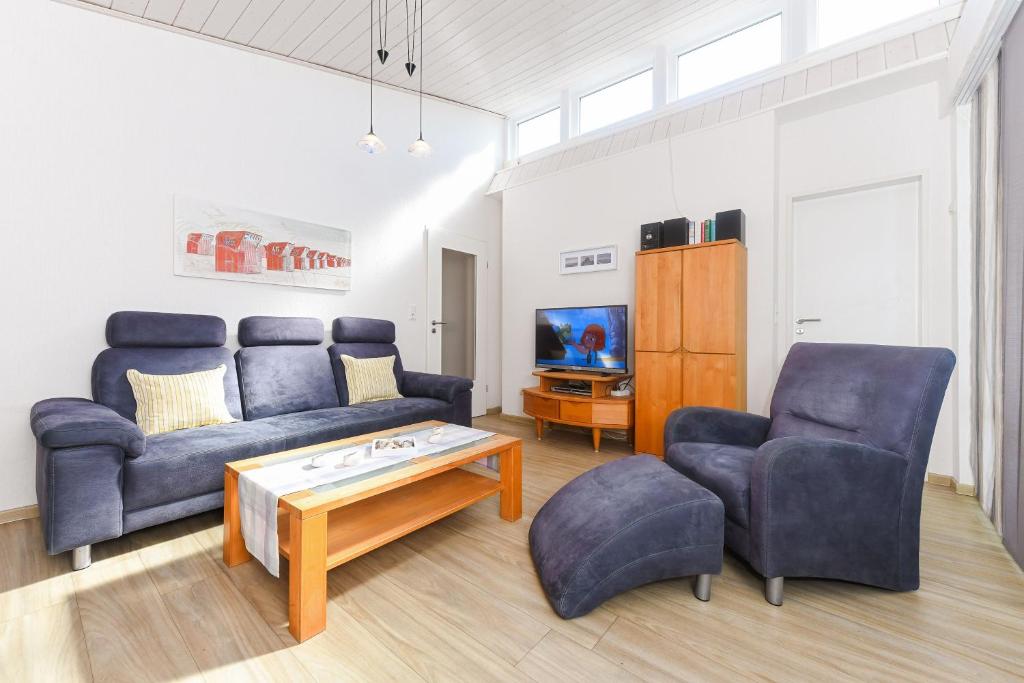 een woonkamer met een bank, 2 stoelen en een salontafel bij Ferienhaus Engelke in Bensersiel