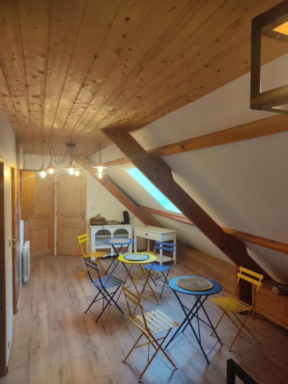 a room with a table and chairs in a attic at Au pied de la colline in Alembon