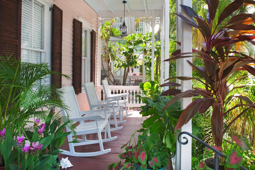 a porch with white chairs and plants on a house at Key West Bed and Breakfast in Key West