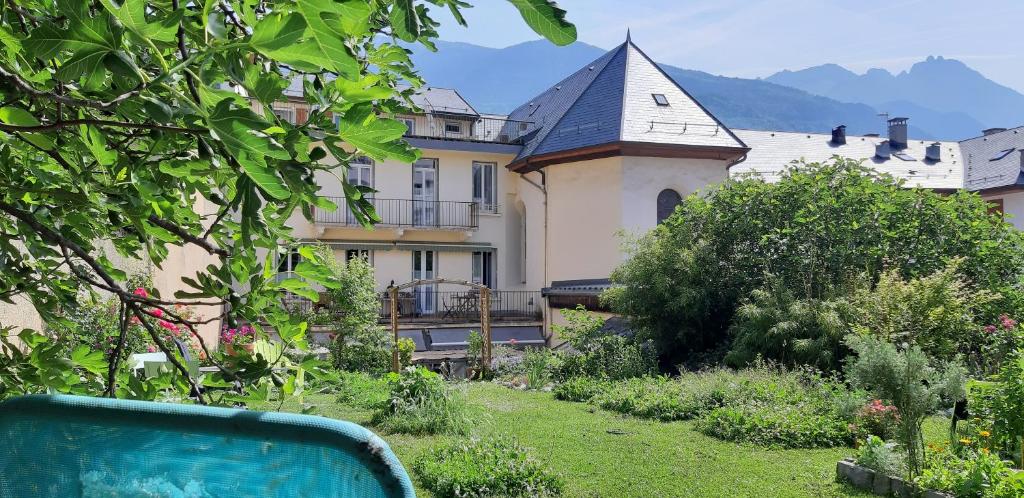 uma casa grande com um jardim em frente em Chambres d'hôtes Nilautpala Dreams em Saint-Jean-de-Maurienne