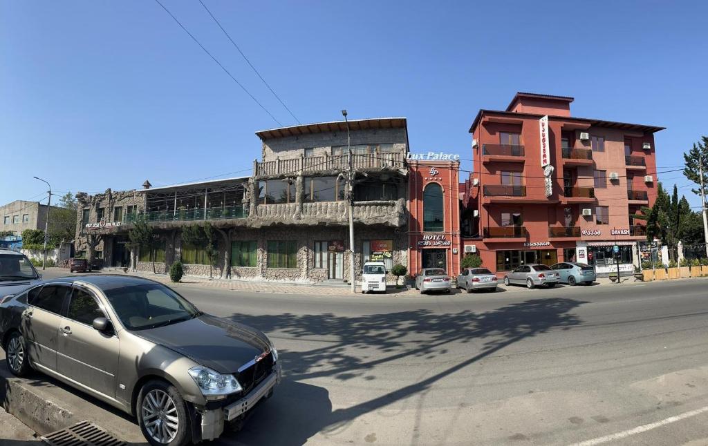 a car parked on a street in front of a building at Lux Palace Hotel in Kutaisi