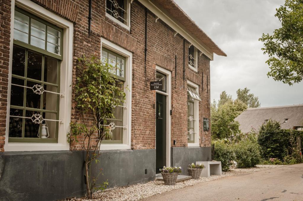 - un bâtiment en briques avec une porte et des fenêtres dans l'établissement Heeren van Acquoy, à Acquoy