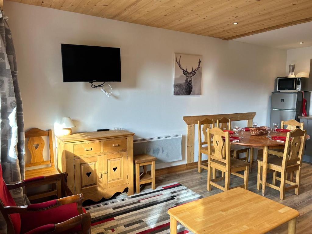 une salle à manger avec une table et une télévision murale dans l'établissement Les Gets - Appartement rénové proche pistes, navette gratuite, parking - FR-1-623-114, aux Gets