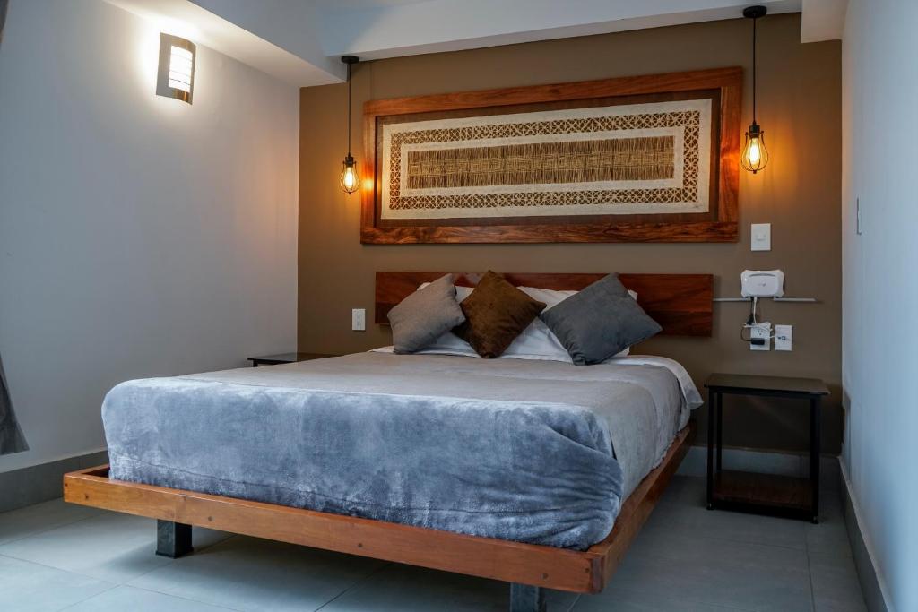 1 dormitorio con 1 cama grande con manta azul en Sky Roma - SUITES & DEPAS, en Ciudad de México