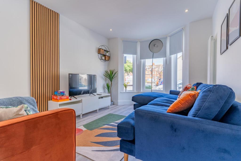 a living room with a blue couch and a tv at Charming 3 BR in Folkestone! in Folkestone