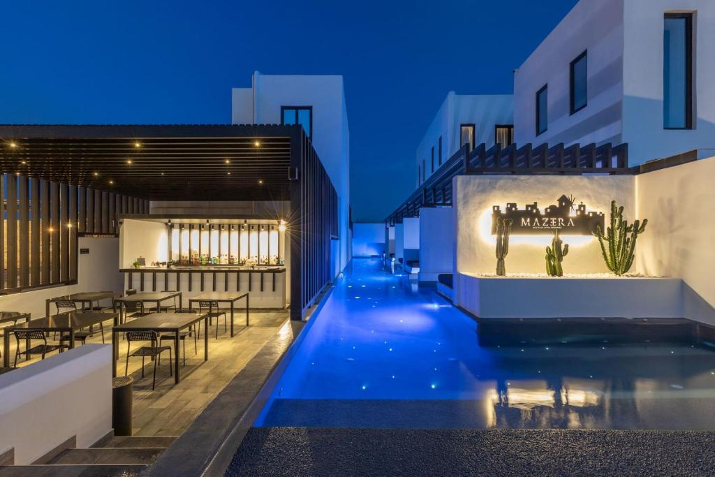 a view of a swimming pool at night with a restaurant at Laguna Suites in Mazera Mykonos in Mikonos