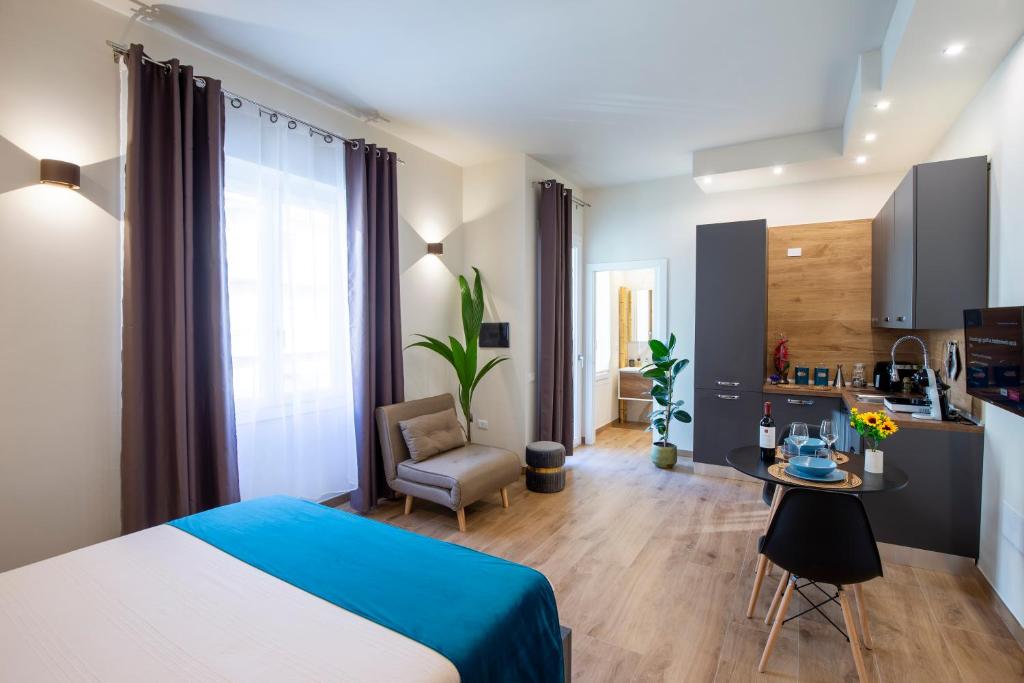 a bedroom with a bed and a table and a kitchen at ML Apartment Cagliari in Cagliari