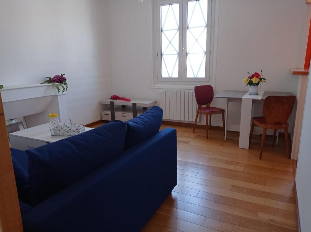 un salon avec un canapé bleu et une table dans l'établissement Foudebassan, à La Teste-de-Buch